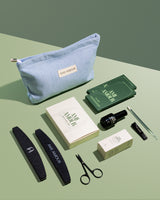 Mani starter kit flat lay — blue Ami Amour pouch, nail file, scissors and prep tools on sage green.